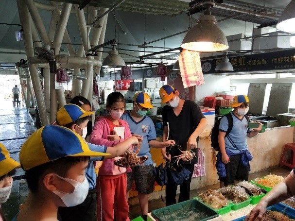 五年級學生至富基漁港實地訪問店家所販賣的海鮮種類與其他問題。
